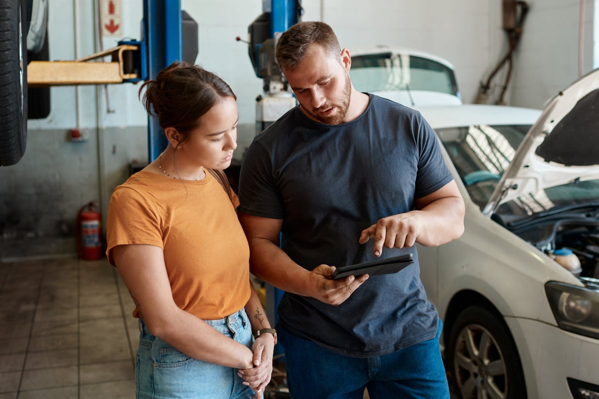 Mechanic working on a vehicle with diagnostic equipment